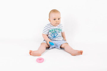 Little kid playing with baby pyramid on white background