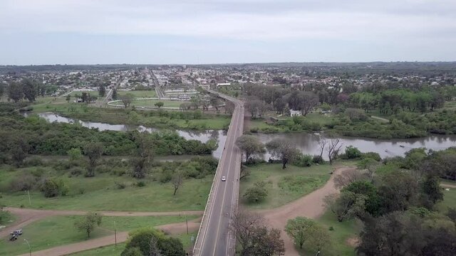 Beautiful drone aerial view of road bridge and river on the border of Quarai city, Brazil and Artigas, Uruguay on sunny summer day. Concept of travel, cityscape, countries, transport, landscape.