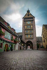 urocza brama wjazdowa w średniowiecznej wiosce Riquewihr, Alzacja, Francja - obrazy, fototapety, plakaty