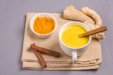 Moon milk for better sleep. Turmeric Golden Milk with Cinnamon. Ayurvedic drink. Popular drink. Golden latte on a light background. Indian drink turmeric golden milk in a cup
