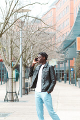 Fototapeta premium joven afro emprendedor en la ciudad de lyon francia hablando con su smartphone