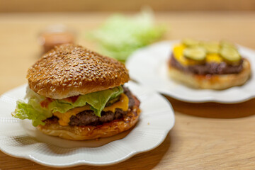 Process of cooking self made burgers at home. Cheesy burger on a white plate