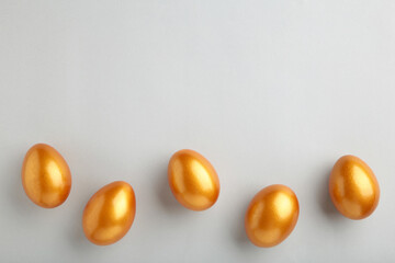 Gold Easter eggs on grey background. Spring concept.