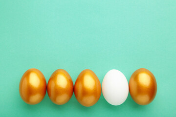 Gold egg with white on mint background