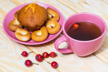 Homemade round bagels with muffins in a purple plate and rosehip tea. Idea for a delicious breakfast or dinner