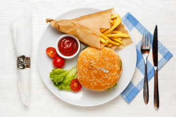 Hamburger, tomato sauce, and fried potatoes in a paper bag on a white plate.