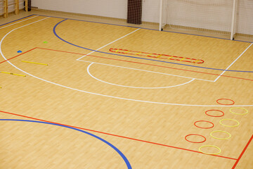 Gym for playing futsal, mini-football. Folded wooden parquet on the field of hall for mini-football. Futsal ball and bright line markings on the floor. Floor sports hall with bright lines of marking
