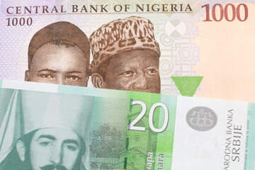 A macro image of a blue, purple and green one thousand  naira note from Nigeria paired up with a green and white twenty dinar banknote from Serbia.  Shot close up in macro.