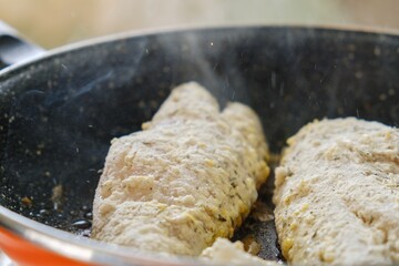 Cooking healthy food from fish, seafood. Fried fish breaded in a pan.