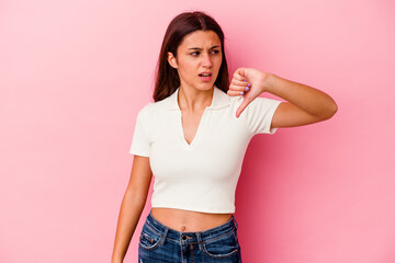 Young Indian woman isolated on pink background showing thumb down and expressing dislike.