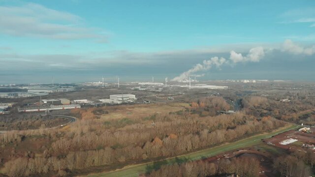 Aerial drone shot of smoking chimneys in industrial landscape, Avonmouth UK