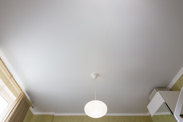 Stretch white matte ceiling close-up in a bedroom