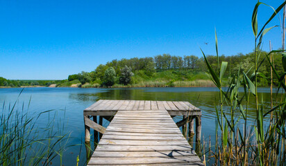 Long Old wooden pier and beautiful lake. Empty on small country lake. of summer. Place for text and fishing