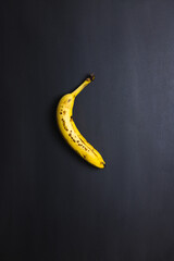 Ripe banana on black background, vertical