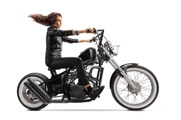 Full length profile shot of a woman with a long hair riding a custom chopper motorbike