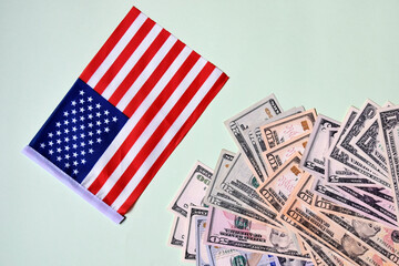 Pile of paper dollars and American flag. Top view. Close-up. Selective focus. Copy space.