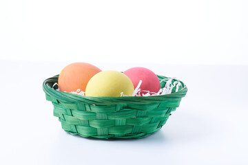 Multi colors Easter eggs in the woven basket isolated on white background with clipping path. Selective focus