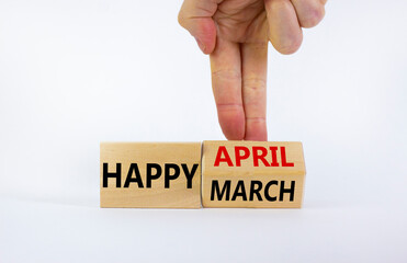 Symbol for the change from March to April. Businessman turns wooden cubes and changes words 'Happy March' to 'Happy April'. Beautiful white background, copy space. Happy April concept.