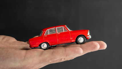 Red Little model car  on the palm. buy or insurance car concept.