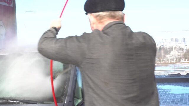 High pressure washer. Car washing and detailing. A man washes a car on his own at a manual car wash