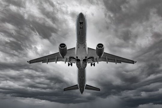 Airplane In The Sky At Sunrise Or Sunset. Black And White Photo.