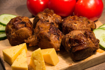 Shish kebab with cucumber and tomato on a wooden board - 419220251