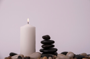 relaxation therapy with a candle between stones