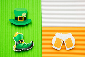 St Patricks Day hat and beer on green and orange background with copy space