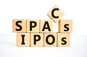 SPACs vs IPOs symbol. Cubes with words 'SPACs, special purpose acquisition companies' and 'IPOs, initial public offering' on beautiful white background, copy space. Business and SPACs vs IPOs concept.