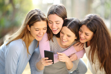 Fototapeta na wymiar Four happy women checking smart phone content