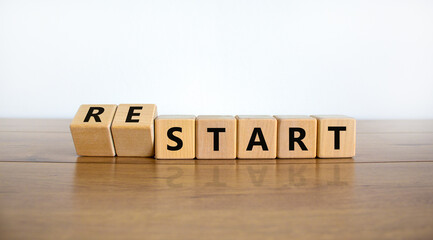 Start or restart symbol. Turned wooden cubes and changed the word 'start' to 'restart'. Beautiful wooden table, white background. Business, start or restart concept. Copy space.