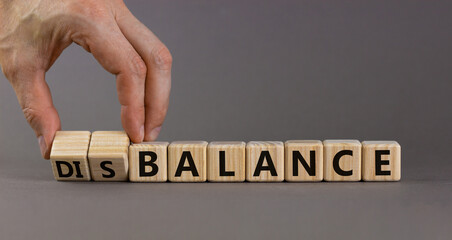 Balance or disbalance symbol. Businessman turns cubes and changes the word disbalance to balance....