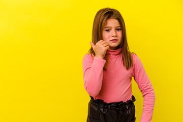 Little caucasian girl isolated on yellow background shocked pointing with index fingers to a copy...