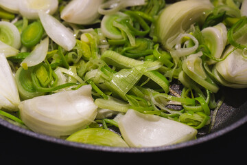 quartered onions and chopped leek in a pan

