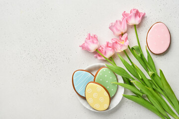 Easter table setting with floral decor and plate with easter gingerbread on gray table. Elegance dinner. Mock up. Top view.