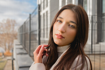 Fototapeta premium Close-up portrait of a young female model posing in a business district of the city