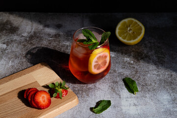 Cold drink in crystal glass with strawberry and lemon mint ice cocktail