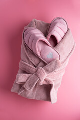 cozy home set with slippers and bathrobe against pink background. concept composition