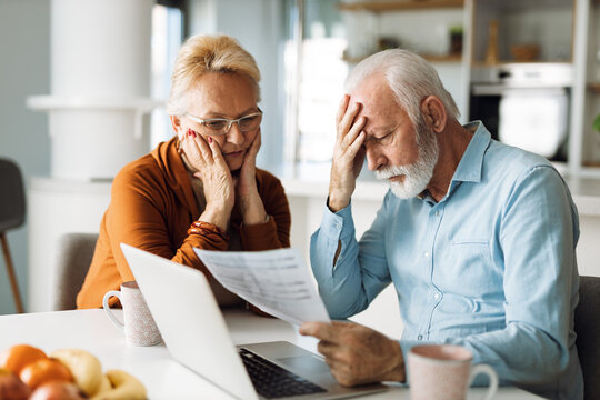 Worried senior couple feeling stressed while have to pay their bills over Internet