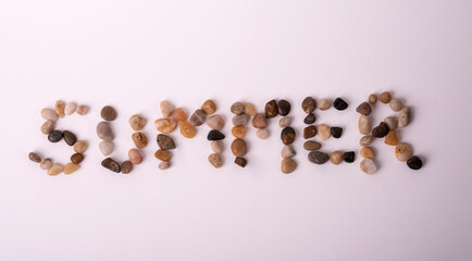 summer written with beach stones