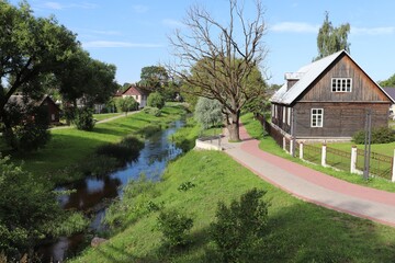 Fototapeta na wymiar Private houses on the banks of a small river flowing through the Latvian city of Rezekne on summer days 2019