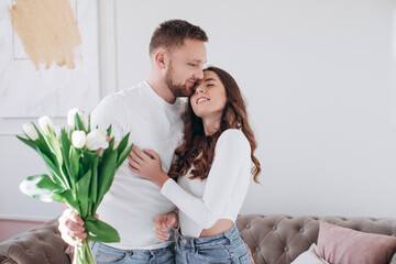 Celebrating Special Occasion. Giving girl a bouquet of colorful wilted tulips. Man greeting lady with international women's day. Couple separation, betrayed, misunderstood wife. 