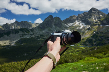 Film camera on the background of mountains landscape