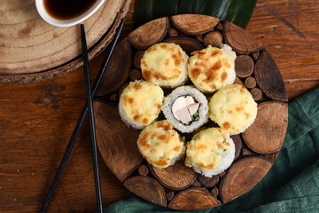 view from above baked rolls with mozzarella and parmesan cheese cap on a wooden board decorated with bamboo leaves