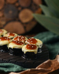 baked rolls with spicy sauce on a wooden background.