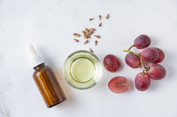 Flat lay is made of natural grape seed oil on white marble background. Natural cosmetics, healthy life style