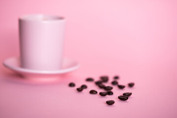 Pink cup of coffee with pink background and coffee beans