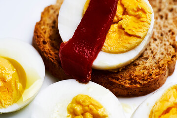 Boiled egg with toast and red pepper, drizzled with olive oil.