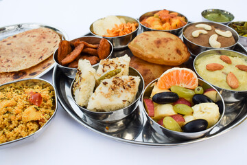 Indian Fasting cuisine Upwas items Thali complere meal for vrat ekadashi.Upawas thali meal with Rajgira puri, paratha,shakarkand halwa,alu sabji,amaranth sheera pakoda, sabudana ata dhokla, chips