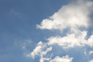 Fototapeta na wymiar Blauer Himmel mit Wolken. die Wolken werden durch die Sonne angestrahlt.